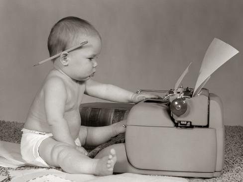 1960s-businesslike-baby-with-pencil-behind-ear-typing-on-typewriter